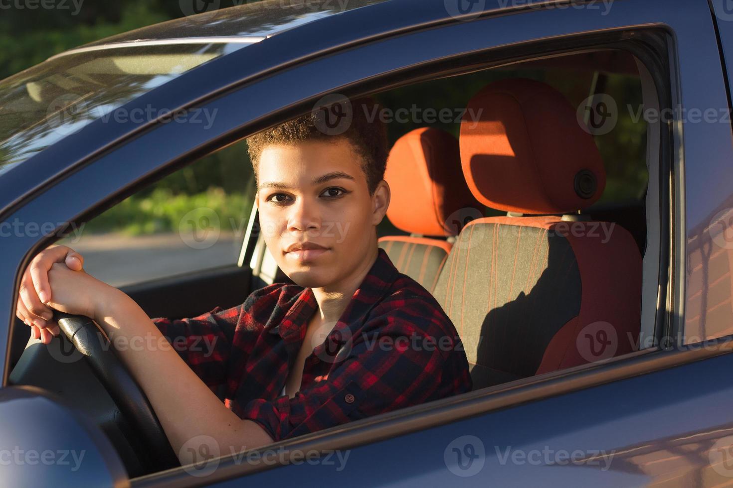 Serious and beautiful african american woman with short hair in a car, lifestyle photo