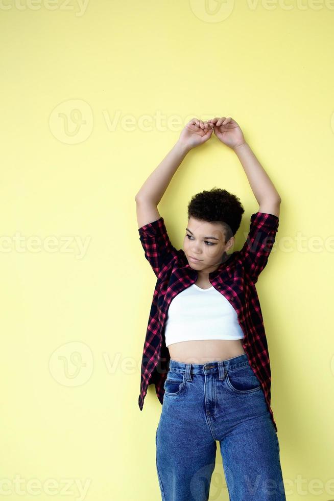 Beautiful african american woman with short hair on a yellow background photo