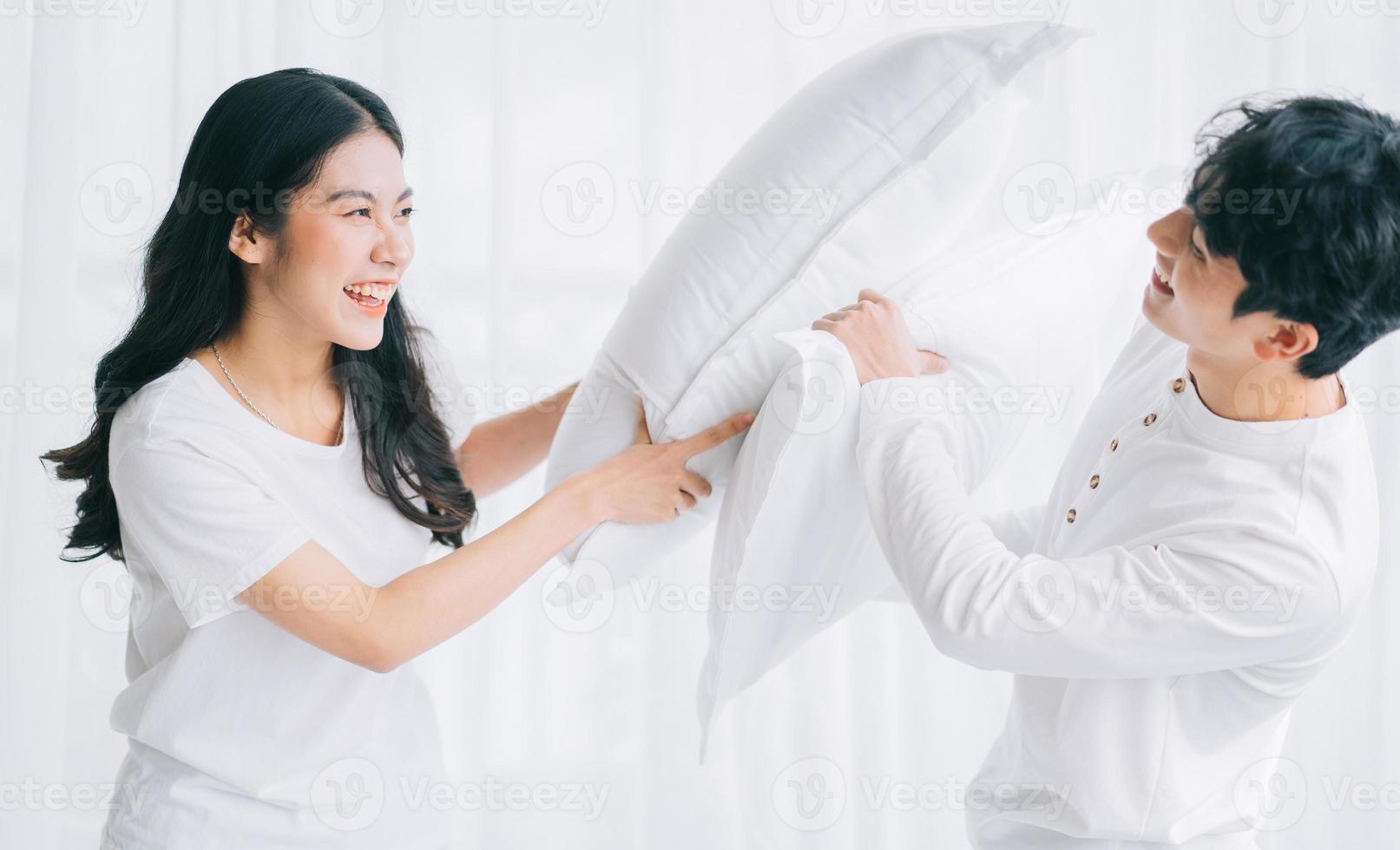 Asian couple playing together in the bedroom photo