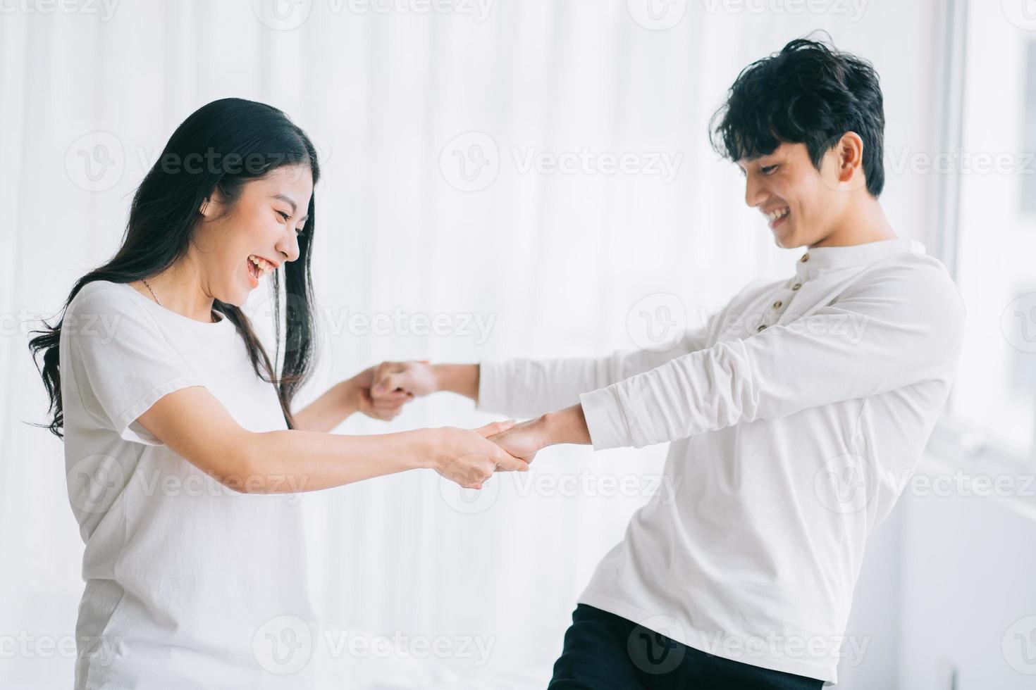 pareja asiática bailando juntos en el dormitorio foto