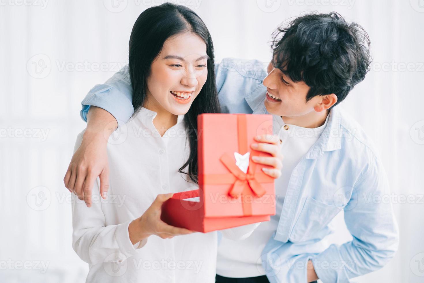 Asian girl feels happy and surprised to receive gifts from her boyfriend on valentine's day photo