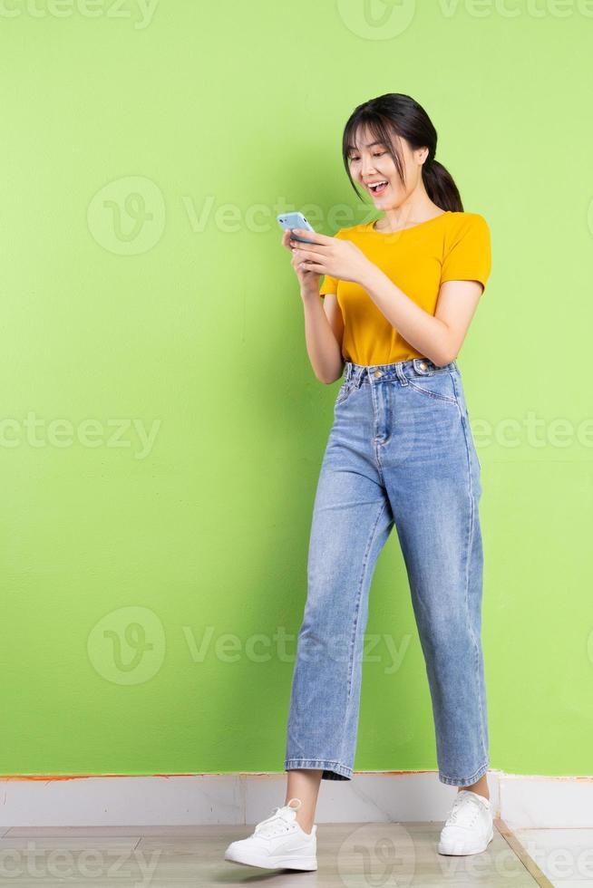 Full body portrait of young Asian girl on green background photo