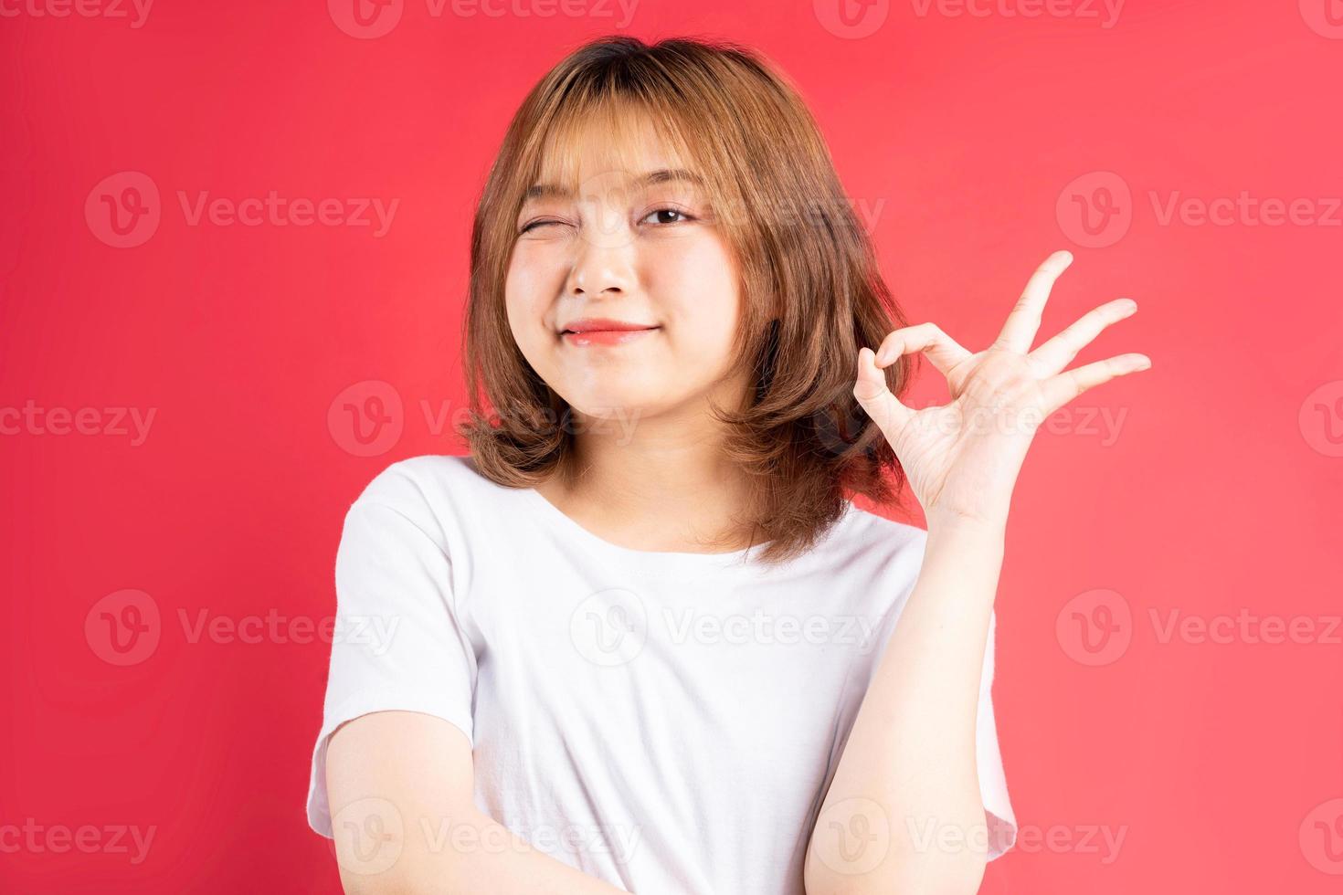 Joven asiática con gestos y expresiones alegres en el fondo foto