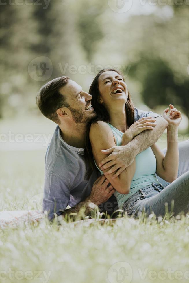 Afectuosa pareja joven sentada en la hierba verde foto