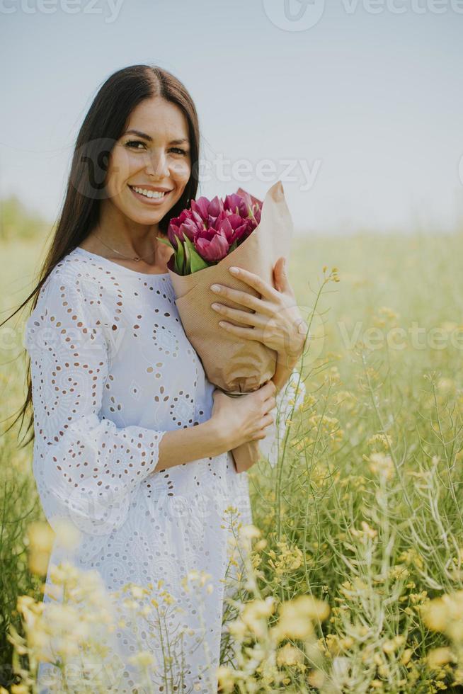 mujer joven en el campo de colza foto