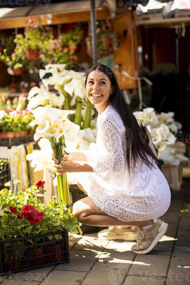 mujer joven comprando flores en el mercado de las flores foto