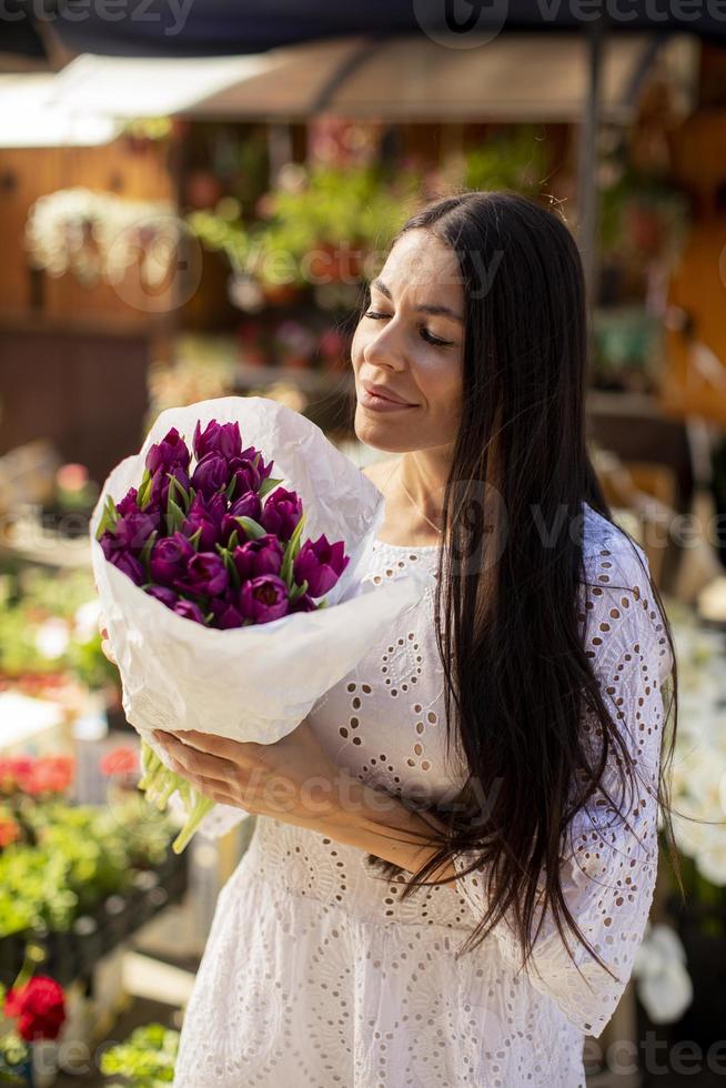 mujer joven comprando flores en el mercado de las flores foto