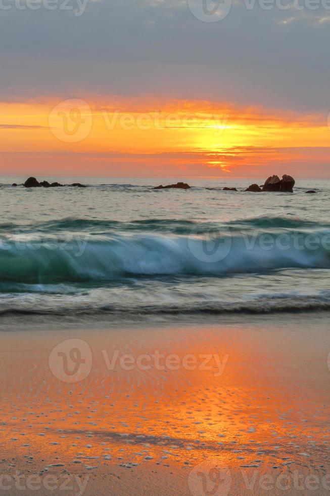 puesta de sol naranja y olas turquesas foto