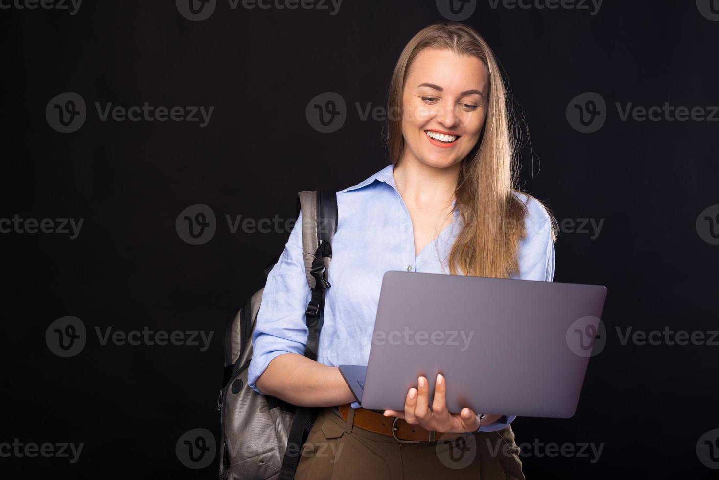 retrato, de, sonriente, joven, mujer casual, usar la computadora portátil, y, llevando, mochila foto