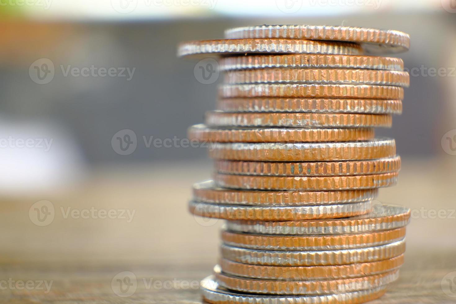 Pila de monedas en el fondo de la tabla y ahorro de dinero y concepto de crecimiento empresarial, concepto de finanzas e inversión foto