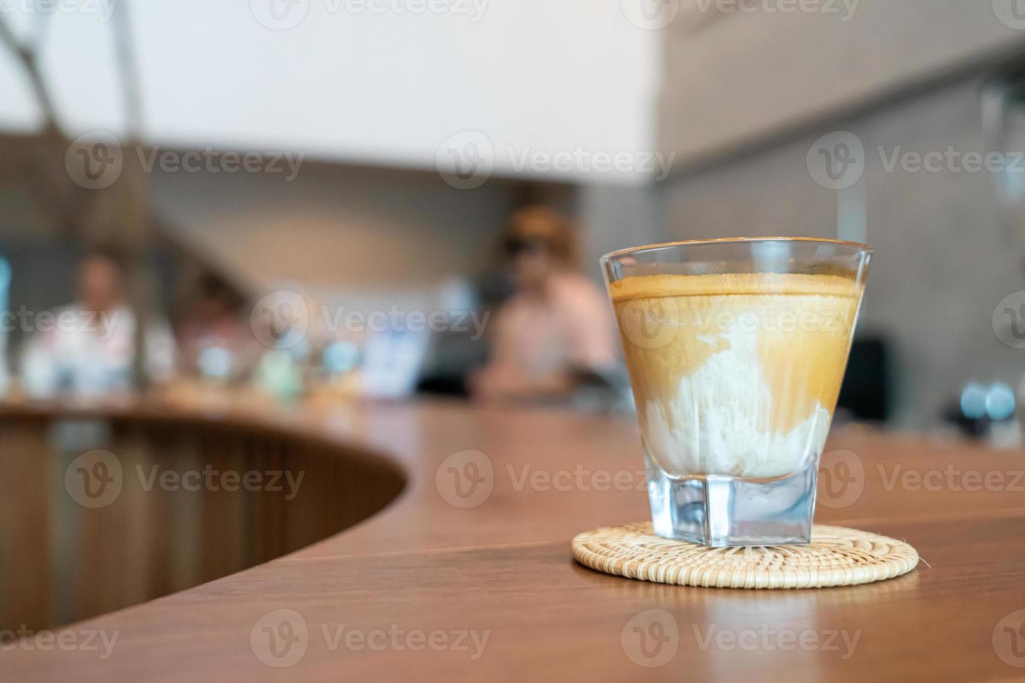 Vaso de café sucio, o leche fría cubierta con un chupito de café expreso caliente, en una cafetería foto