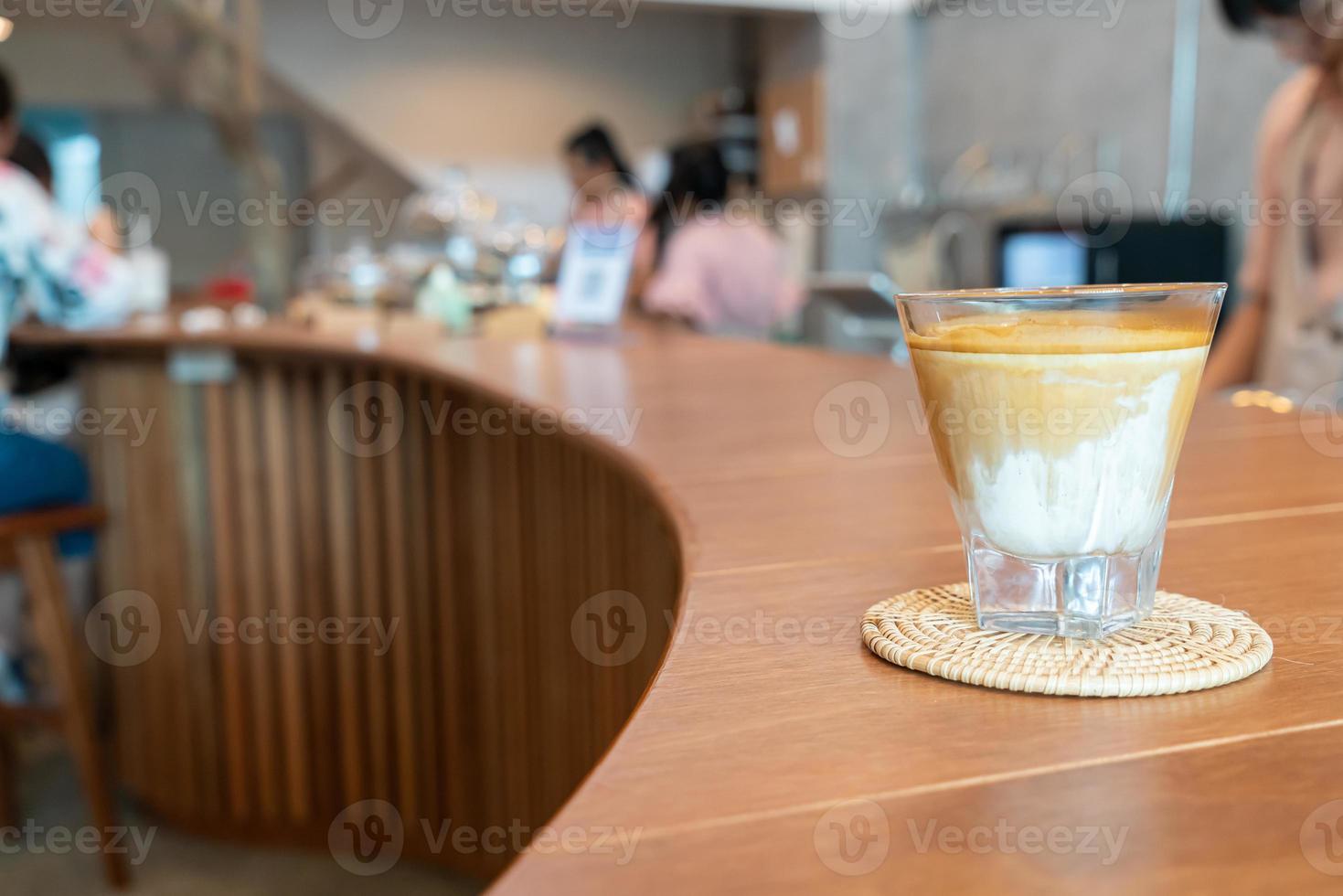 Vaso de café sucio, o leche fría cubierta con un chupito de café expreso caliente, en una cafetería foto