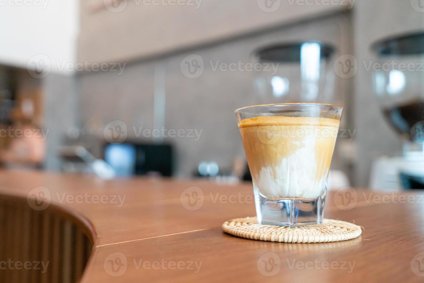 Vaso de café sucio, o leche fría cubierta con un chupito de café expreso caliente, en una cafetería foto