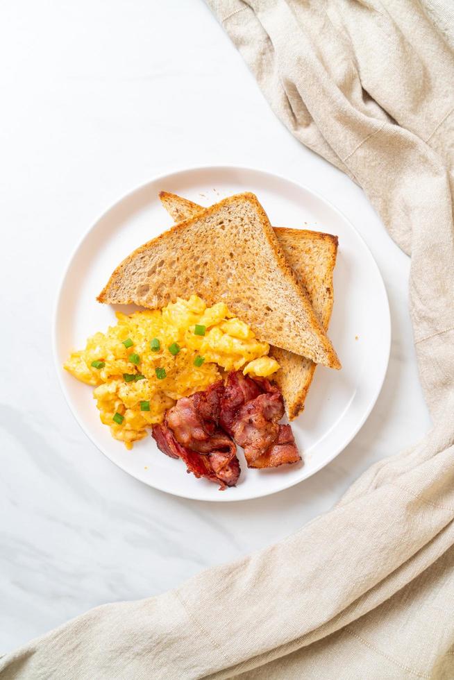 Scrambled egg with bread toasted and bacon for breakfast photo