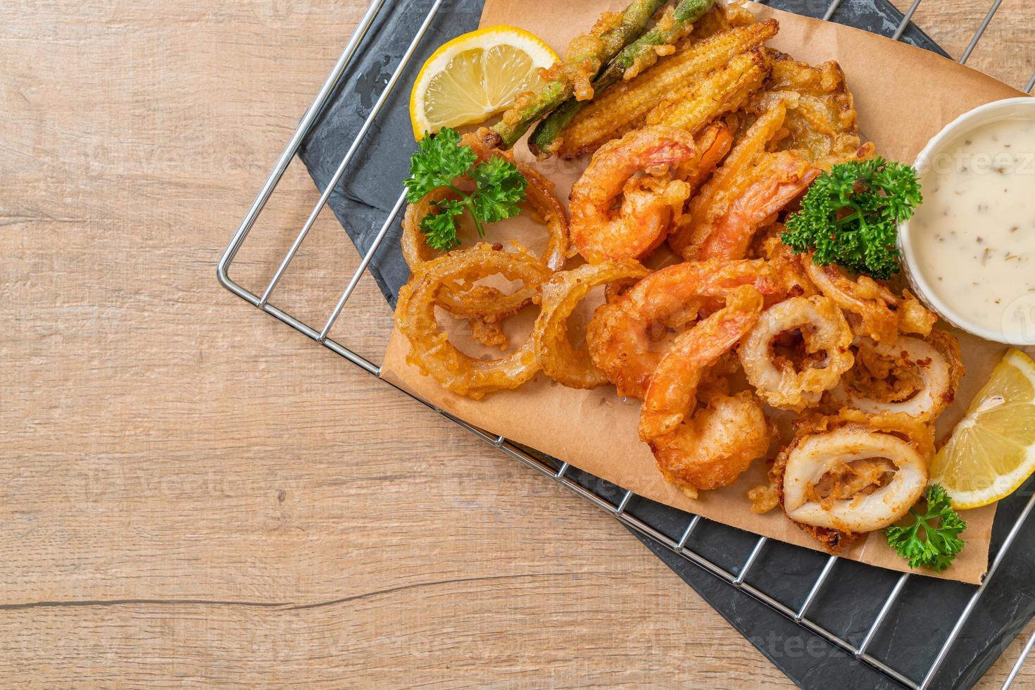 mariscos fritos de camarones y calamares con vegetales mixtos - estilo de comida poco saludable foto