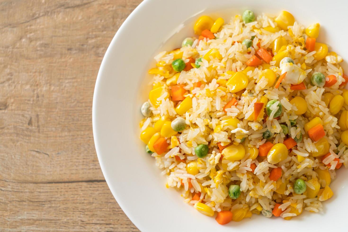 Homemade fried rice with mixed vegetables of carrots, green bean peas, corn, and egg photo