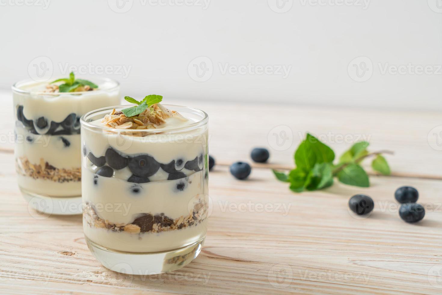 arándanos frescos y yogur con granola - estilo de comida saludable foto