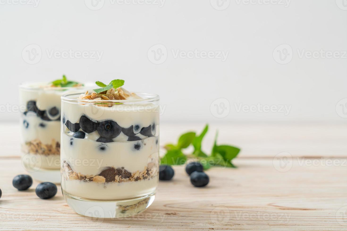 arándanos frescos y yogur con granola - estilo de comida saludable foto