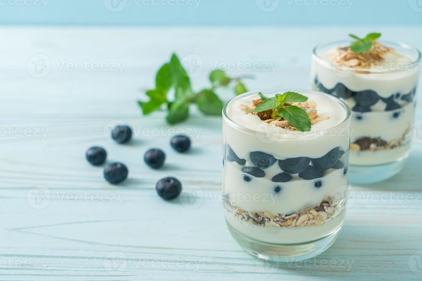 arándanos frescos y yogur con granola - estilo de comida saludable foto