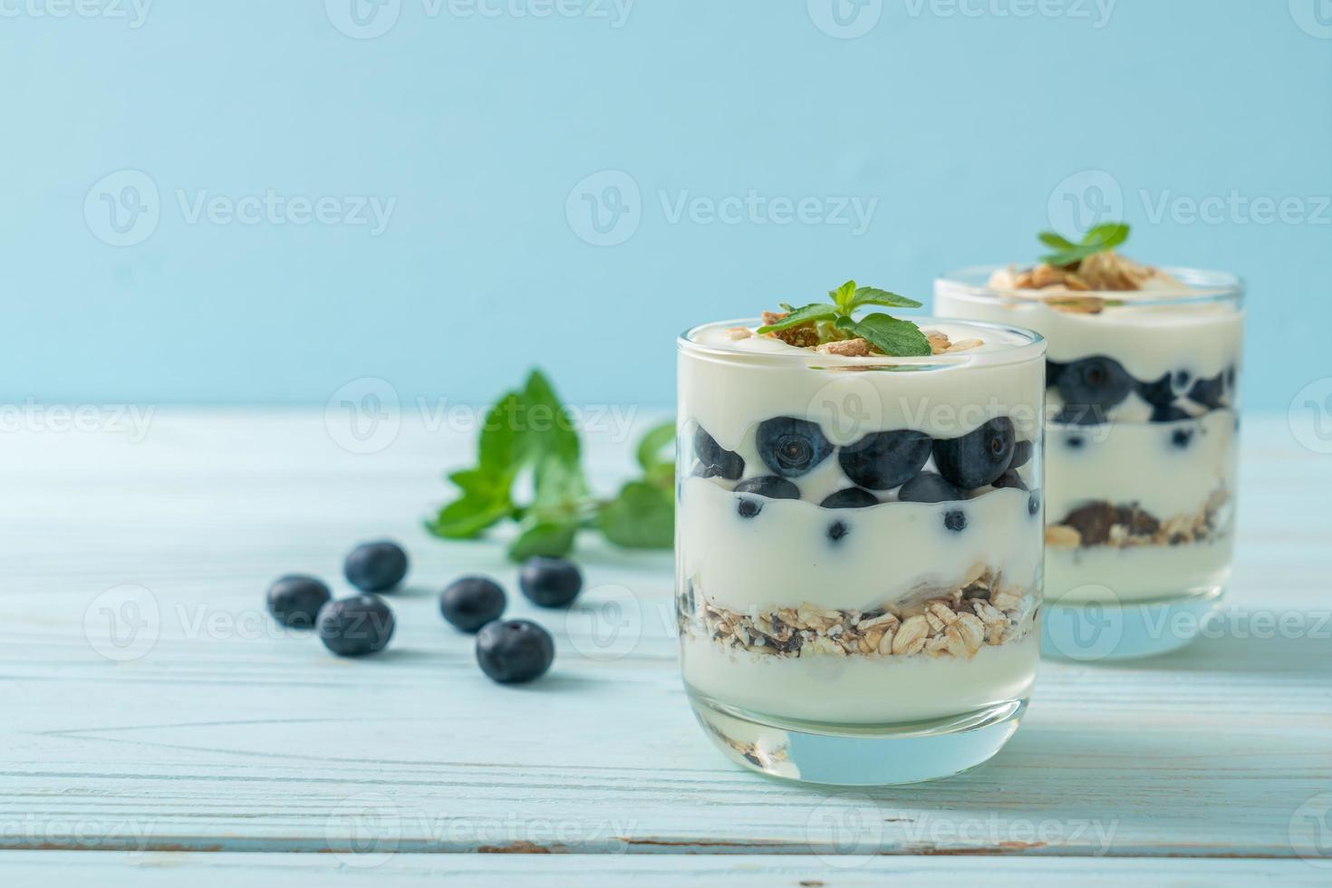 arándanos frescos y yogur con granola - estilo de comida saludable foto