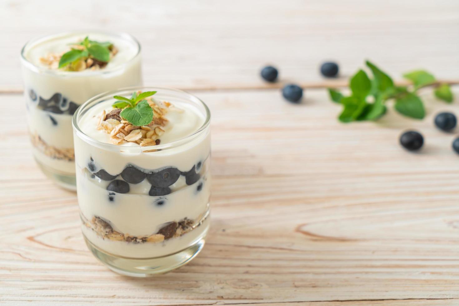 arándanos frescos y yogur con granola - estilo de comida saludable foto