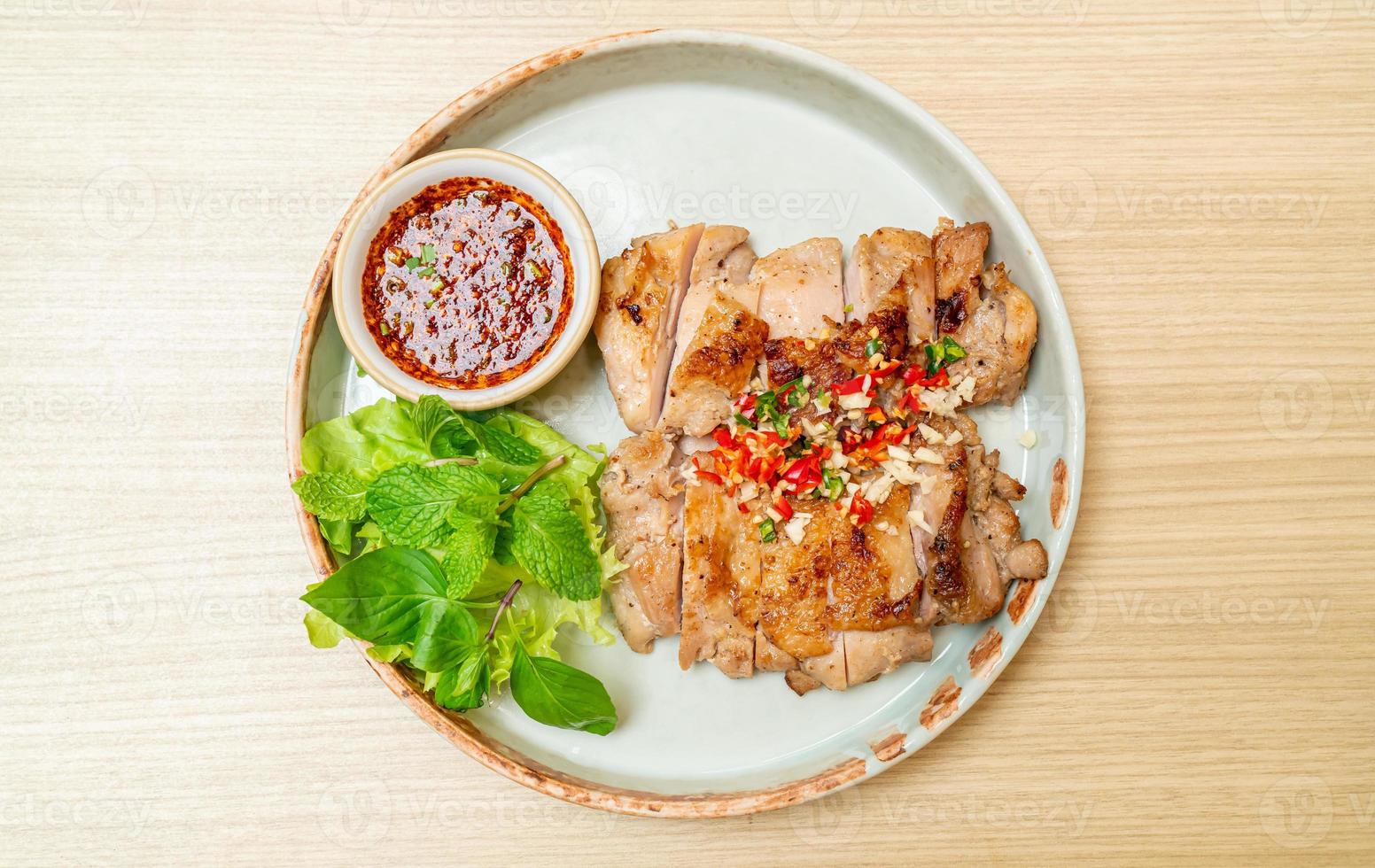 Savory grilled chicken with chili and garlic on a plate photo