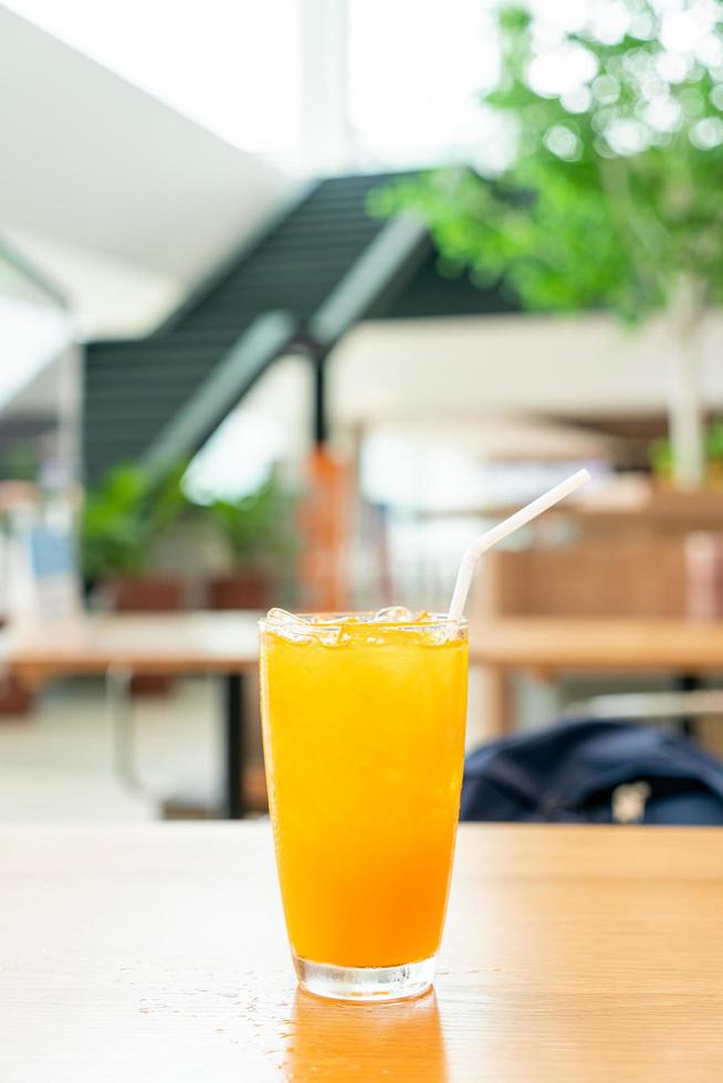 Iced orange juice on wood table in cafe restaurant photo