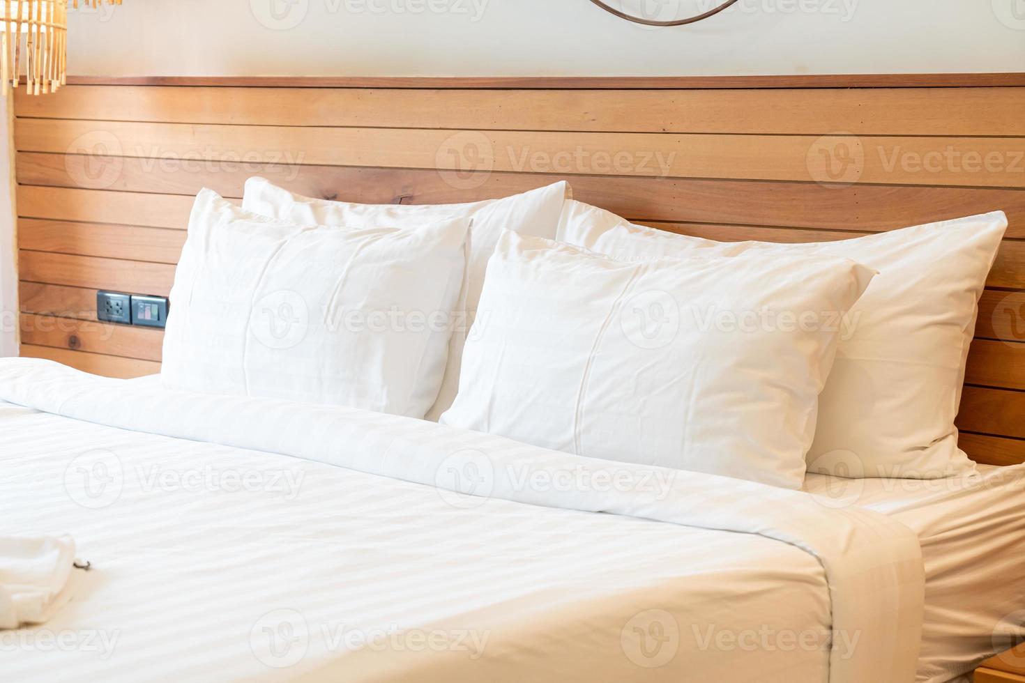 White pillow decoration on bed in bedroom interior photo