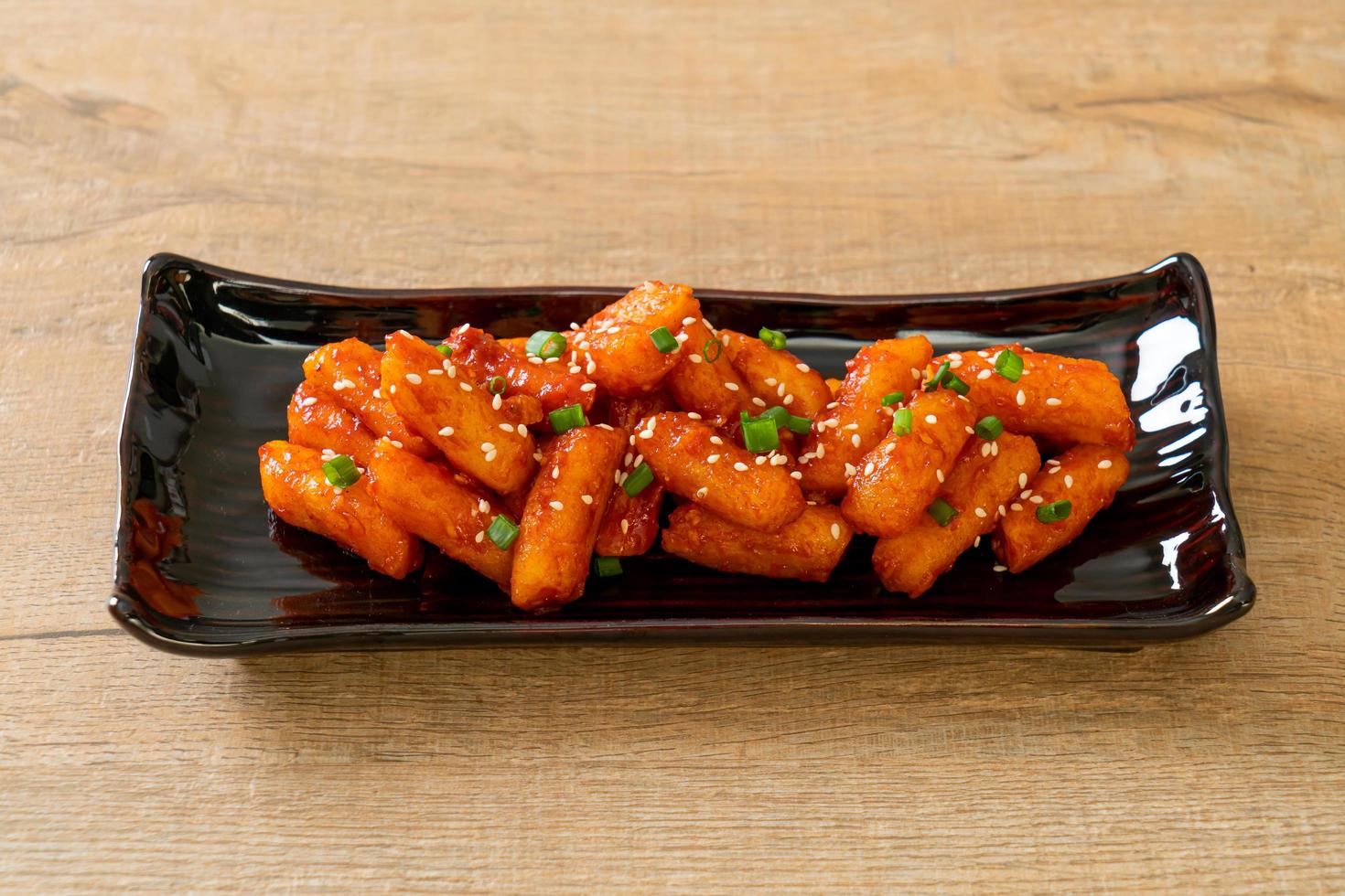 pastel de arroz coreano frito, o tteokbokki, ensartado con salsa picante - estilo de comida coreana foto