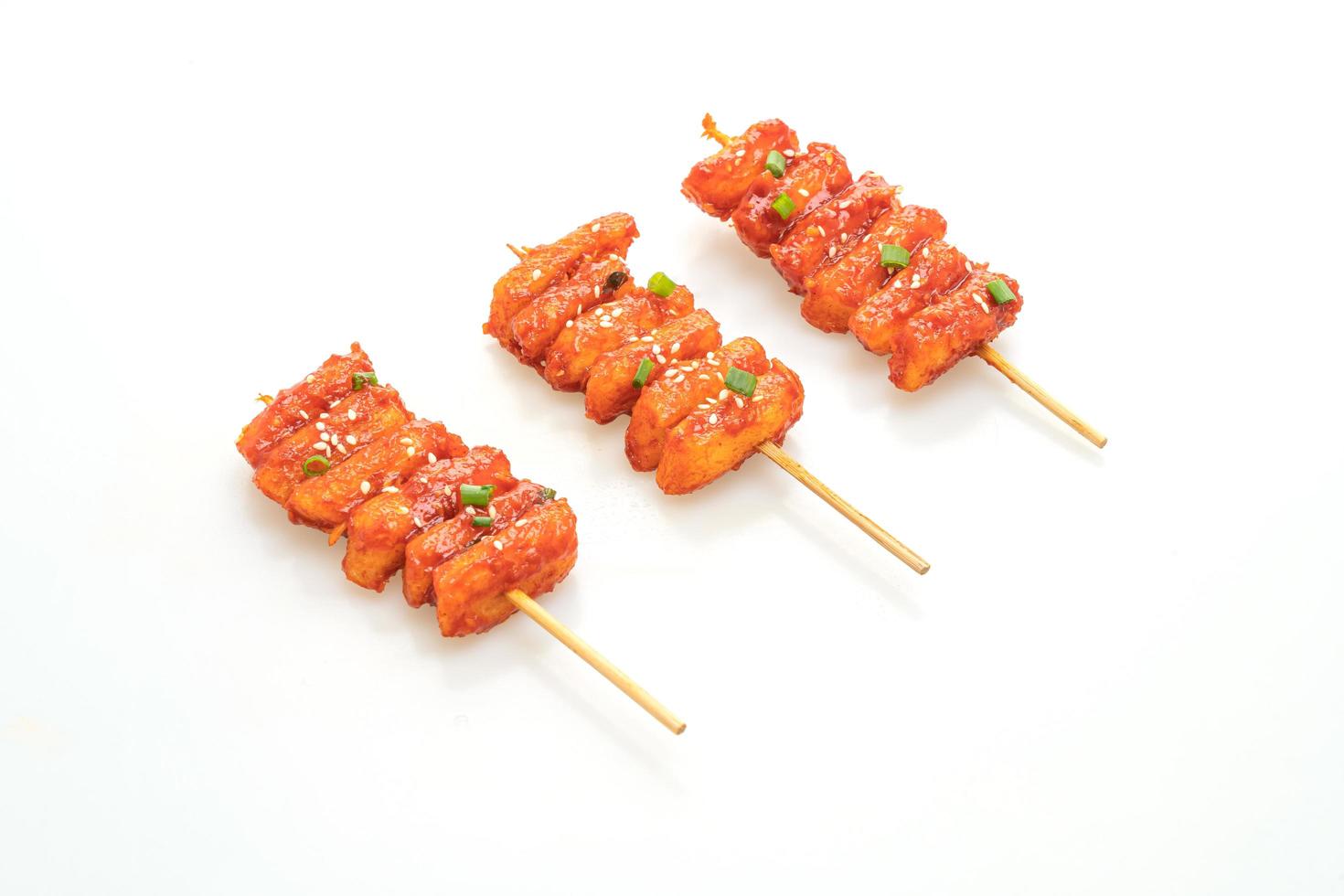 Deep-fried Korean rice cake, or Tteokbokki, skewered with spicy sauce isolated on white background photo