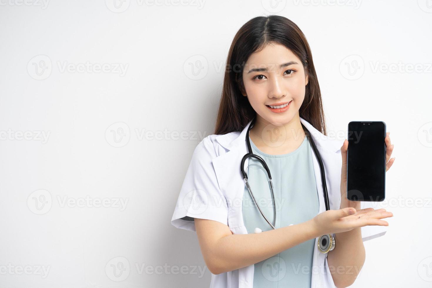 Asian female doctor holding phone in hand photo