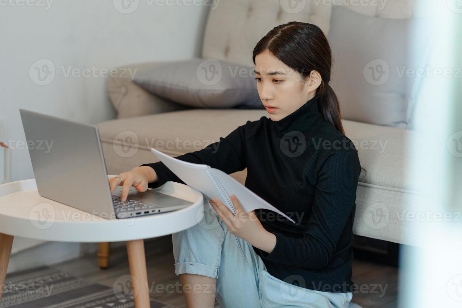 Beautiful Asian woman sitting and calculating income tax photo