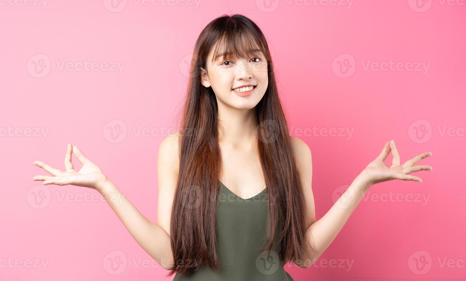 Young Asian girl posing on a pink background photo