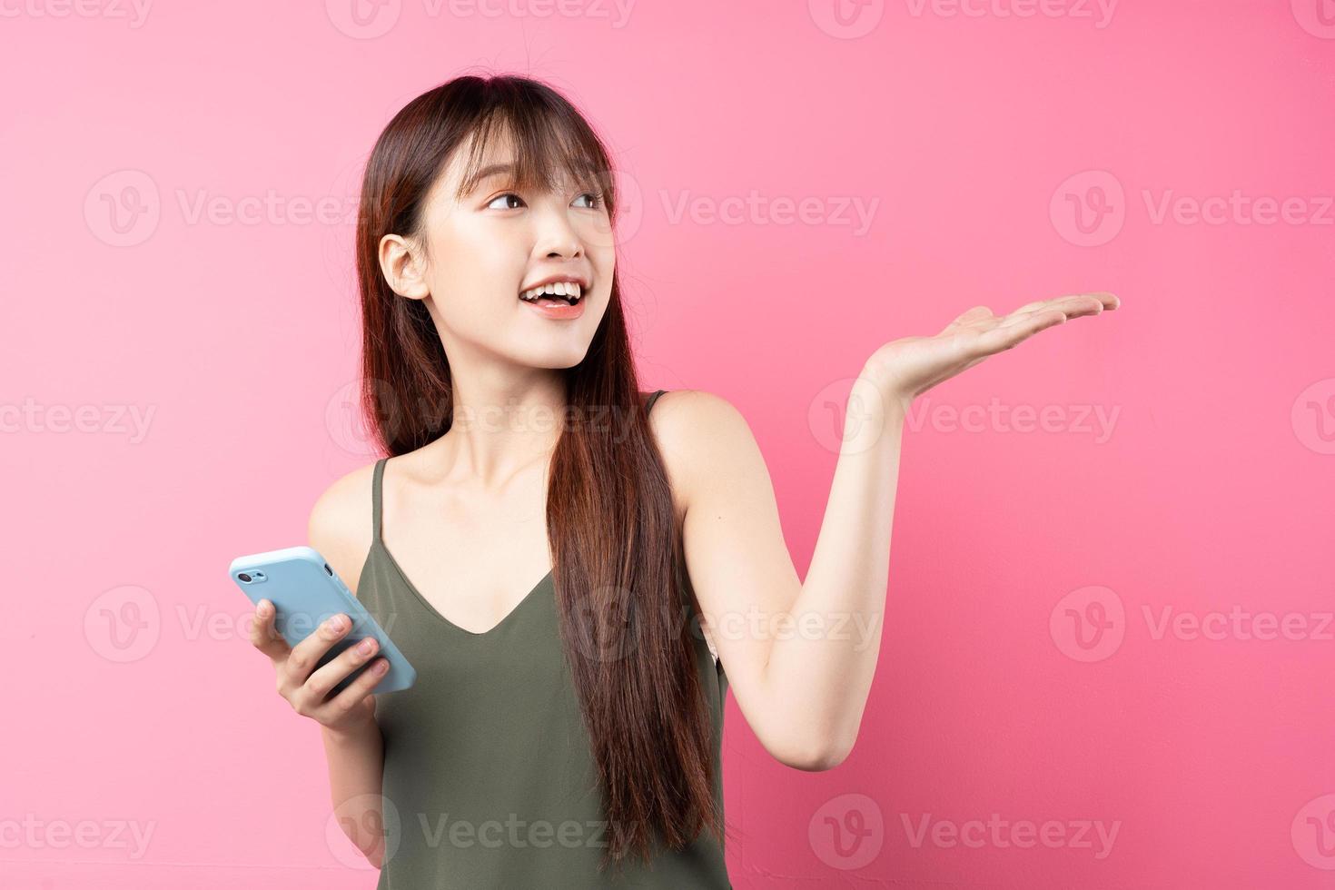 joven asiática posando sobre un fondo rosa foto