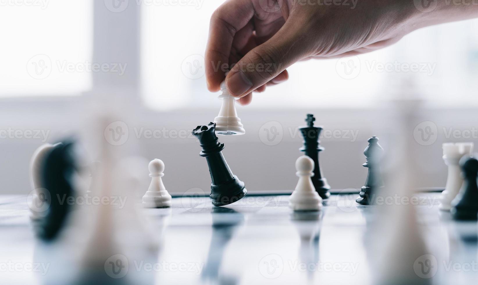 Asian businessman moving chess figure in competition photo