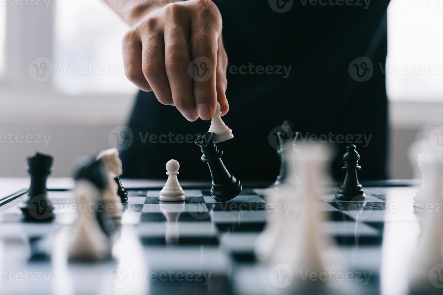 Asian businessman moving chess figure in competition photo