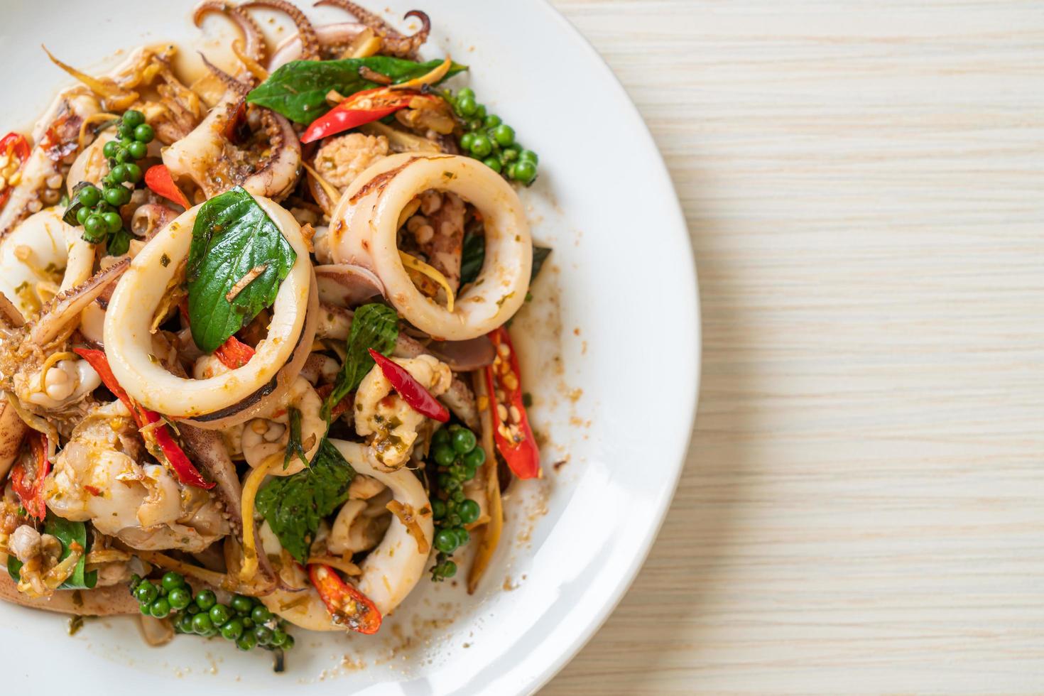 albahaca santa salteada con pulpo o calamar y hierbas - estilo de comida asiática foto