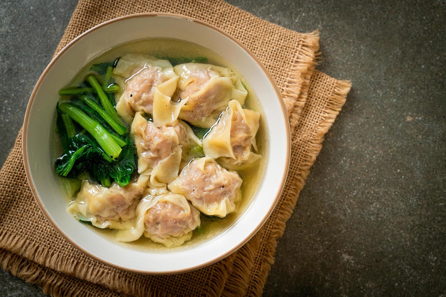 Pork wonton soup or pork dumpling soup with vegetables - Asian food style photo