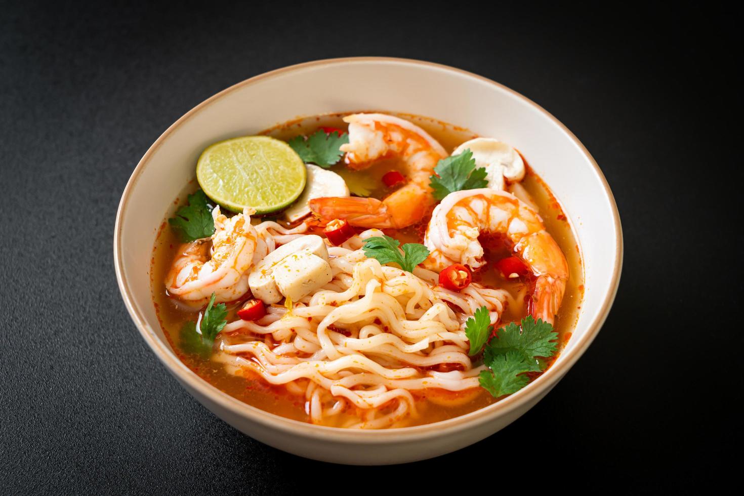 Instant noodles ramen in spicy soup with shrimps, or Tom Yum Kung - Asian food style photo