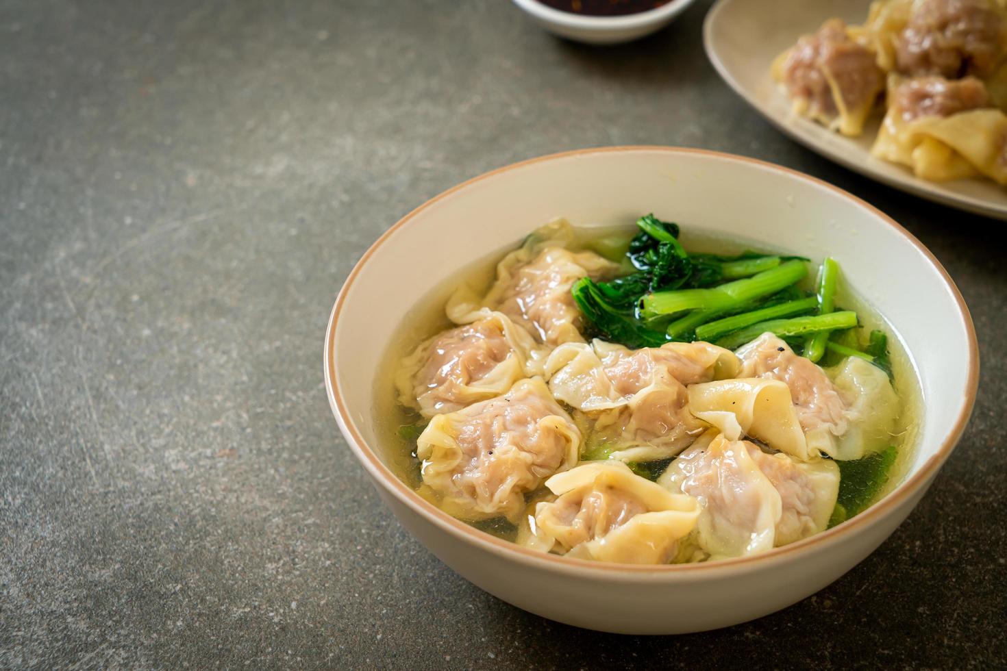 Pork wonton soup or pork dumpling soup with vegetables - Asian food style photo