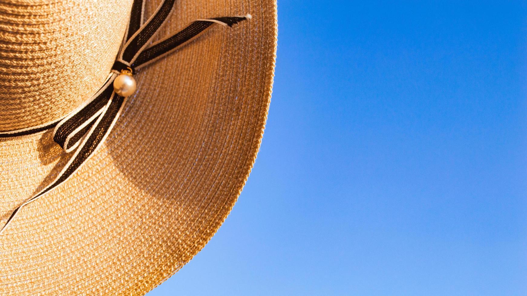 Parte del sombrero de verano sobre fondo de cielo azul claro foto