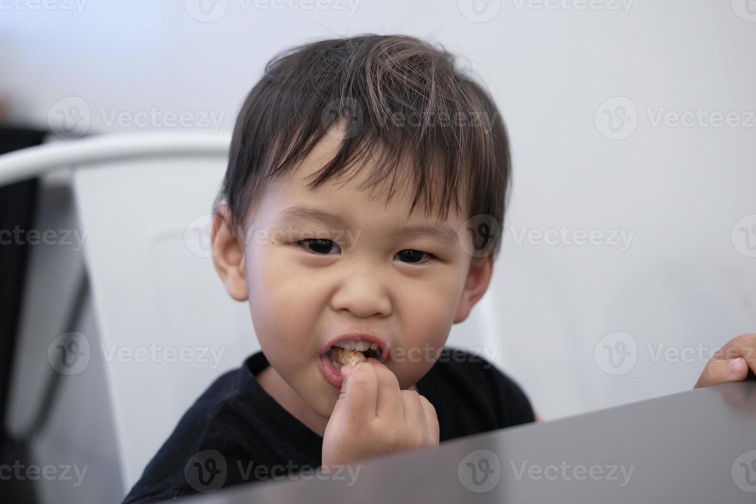 los niños están sentados a comer papas fritas en los restaurantes. mostrando una expresión feliz. foto