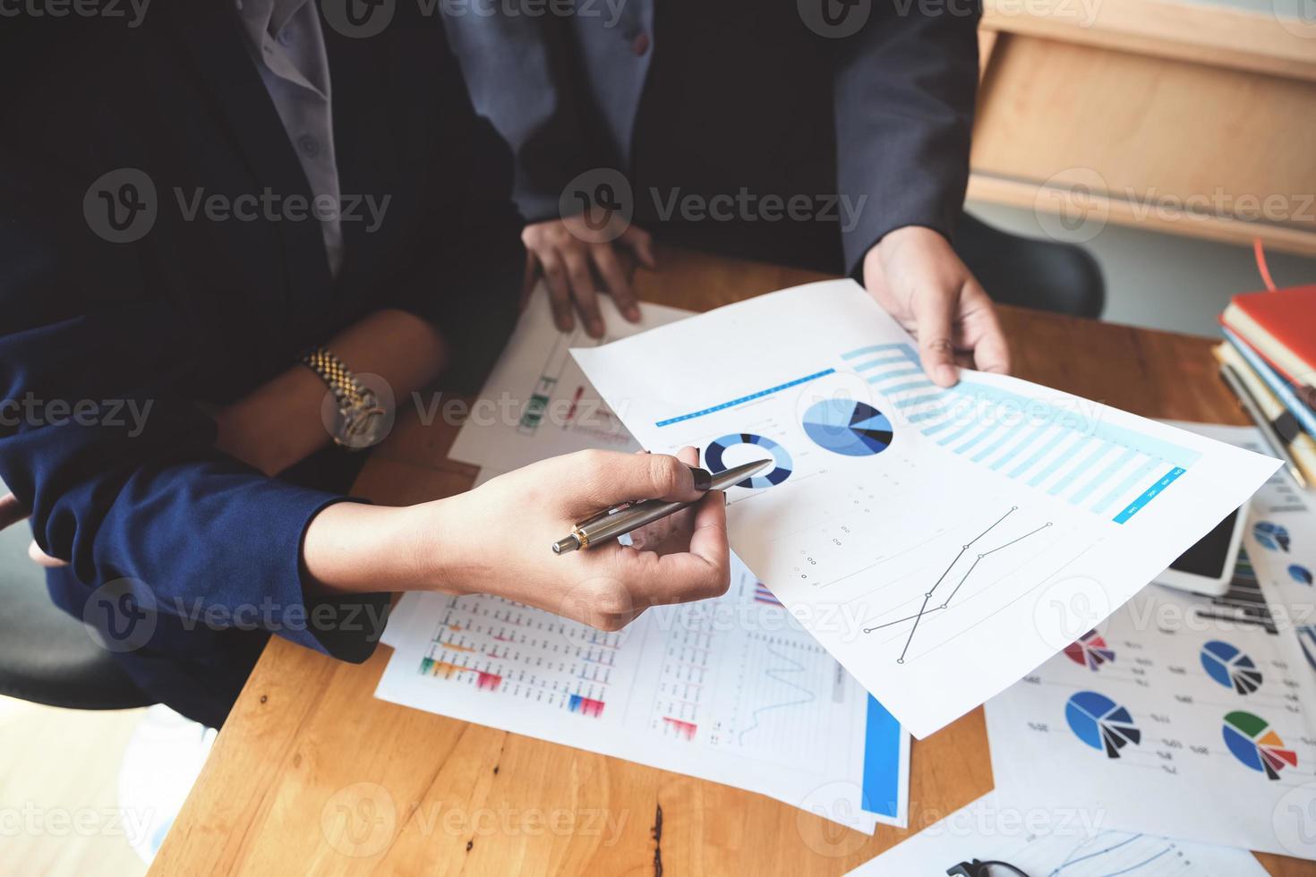 An auditor holds a pen pointing to documents to examine budgets and financial fraud. photo