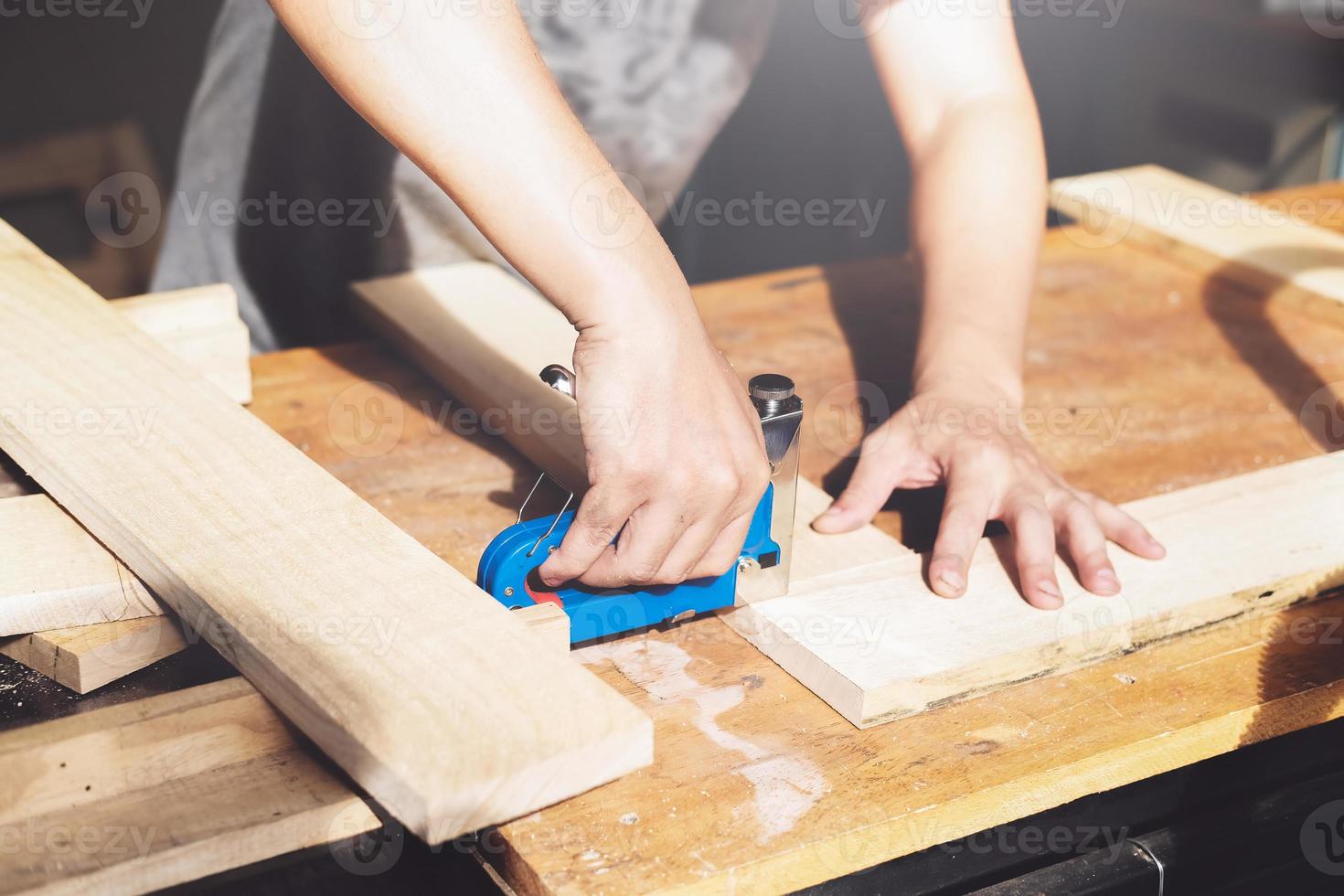 empresario de carpintería sosteniendo una grapadora para ensamblar las piezas de madera según lo ordenaba el cliente. foto