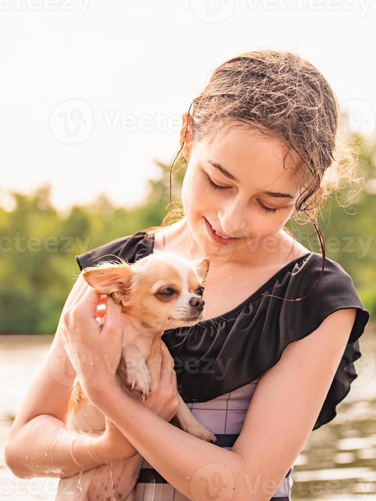 Portrait of a young girl, with her chihuahua. Fluffy puppy. girl and a puppy. Girl near the river photo