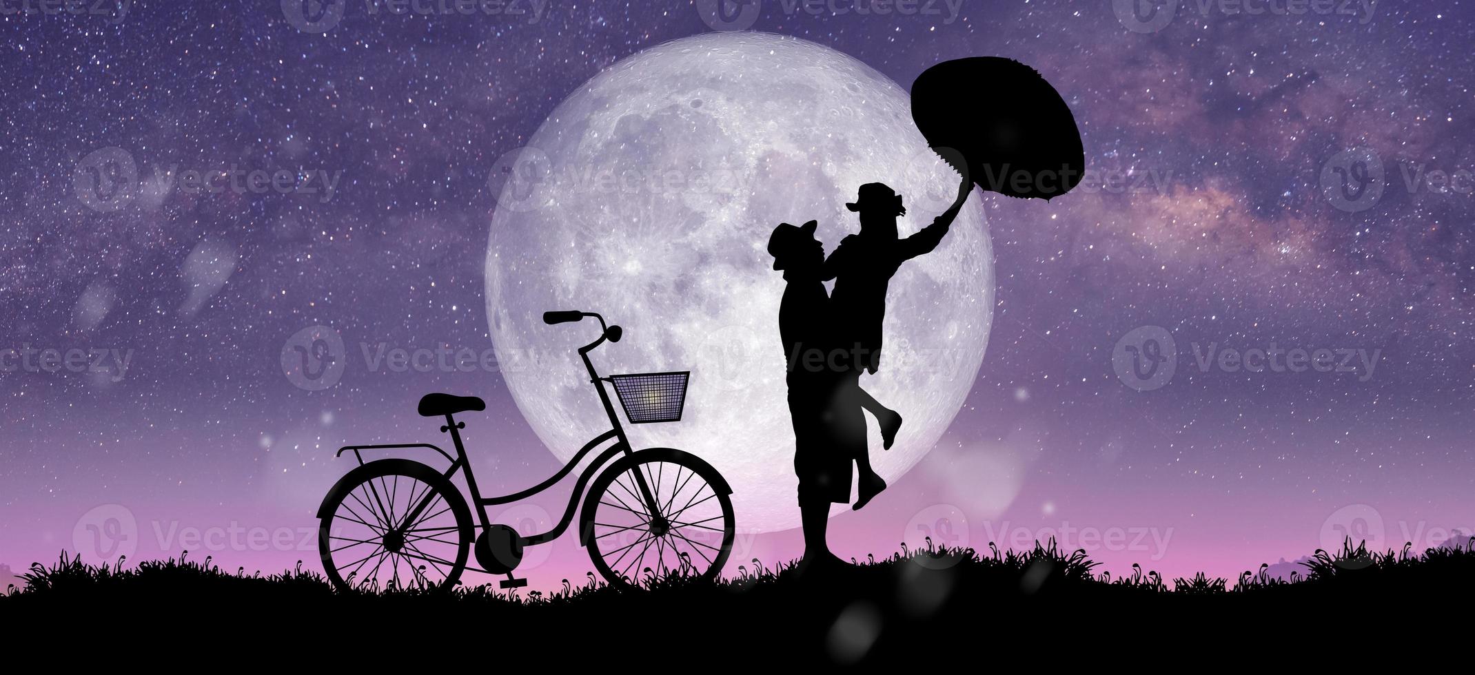 Silhouette at night landscape of couple or lover dancing and singing over the full moon photo