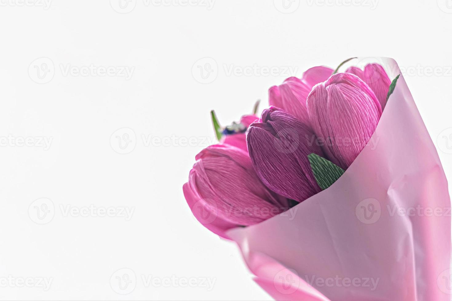 A bouquet of flowers from colored corrugated paper in the form of tulips with a candy inside. Gift, a sign of attention for a holiday, birthday. photo