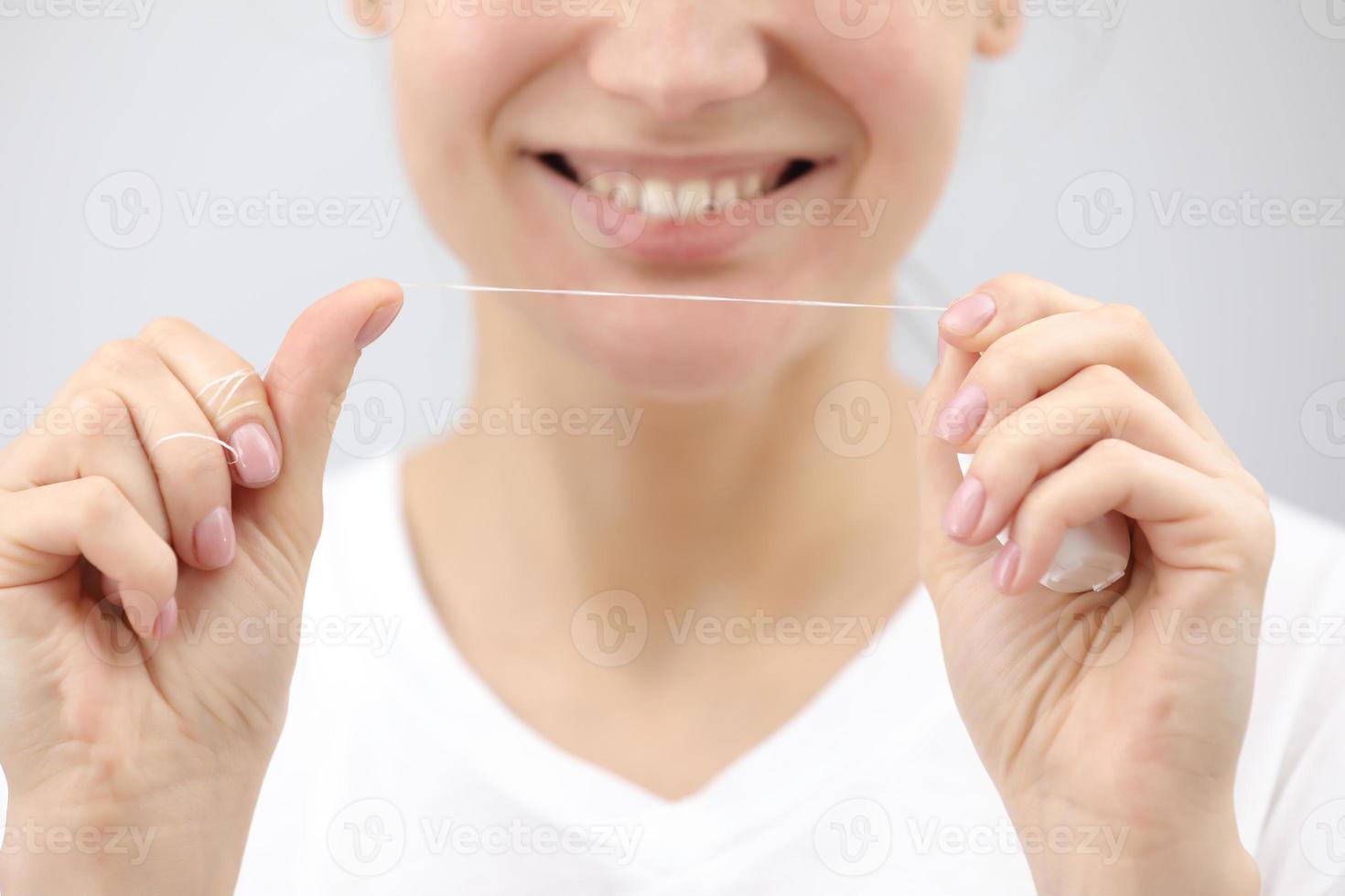 Dental hygiene and care. Dental floss. Young healthy woman face with beauty smile. Beautiful girl. Person healthcare. photo