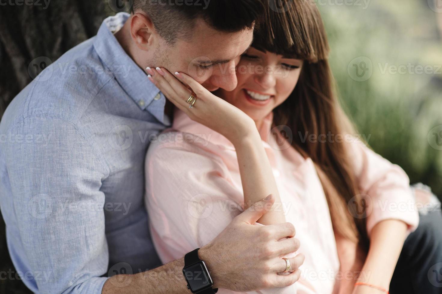 Primer plano de la imagen de la feliz pareja alegre en ropa de verano sonriendo y abrazándose mientras camina en el parque. historia de amor. se besan y abrazan. enfoque selectivo foto