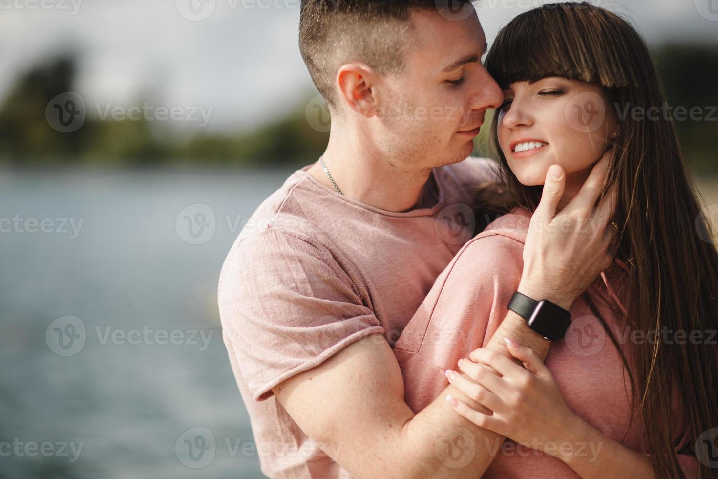 amorosa pareja joven besándose y abrazándose al aire libre. amor y ternura, citas, romance, familia, concepto de aniversario. foto